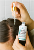 Person applying Scalp Psoriasis Serum to their scalp with a dropper.